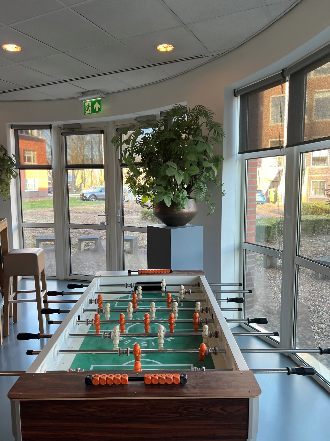 Lichte ontmoetingsruimte met tafelvoetbal en groene accenten