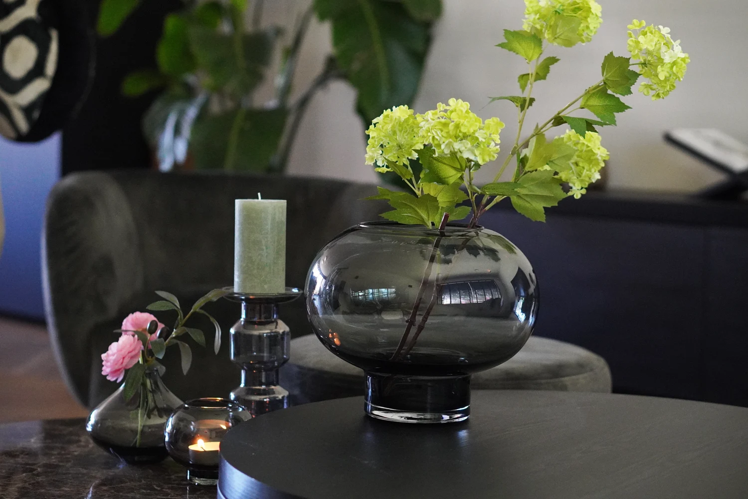 Een verfijnd stilleven van bloemen, glaswerk en woonaccessoires
